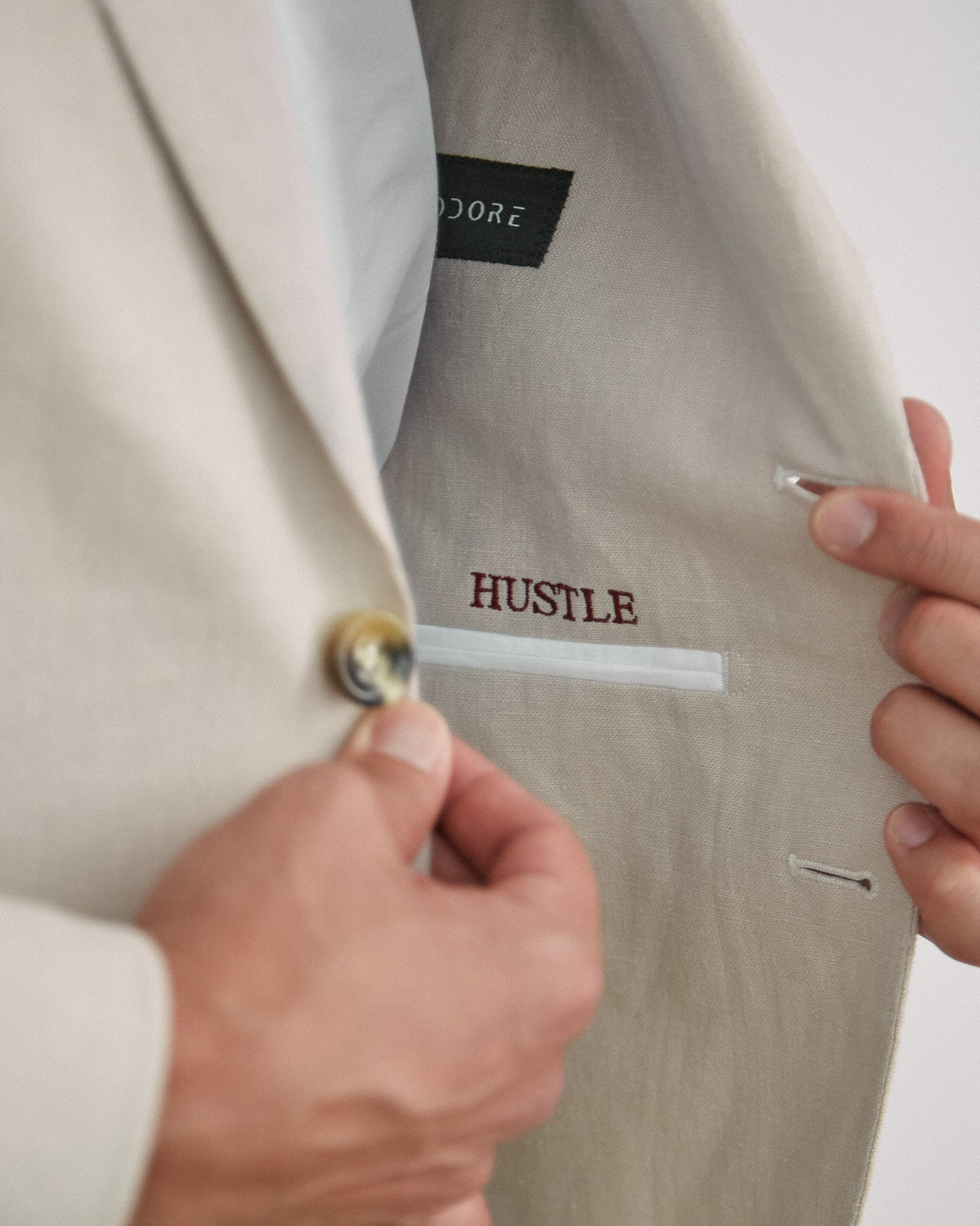 Open jacket showing HUSTLE embroidered in red above the inside pocket