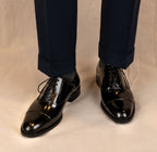 The Haider Black Patent Leather Oxford worn on a model's feet, front view