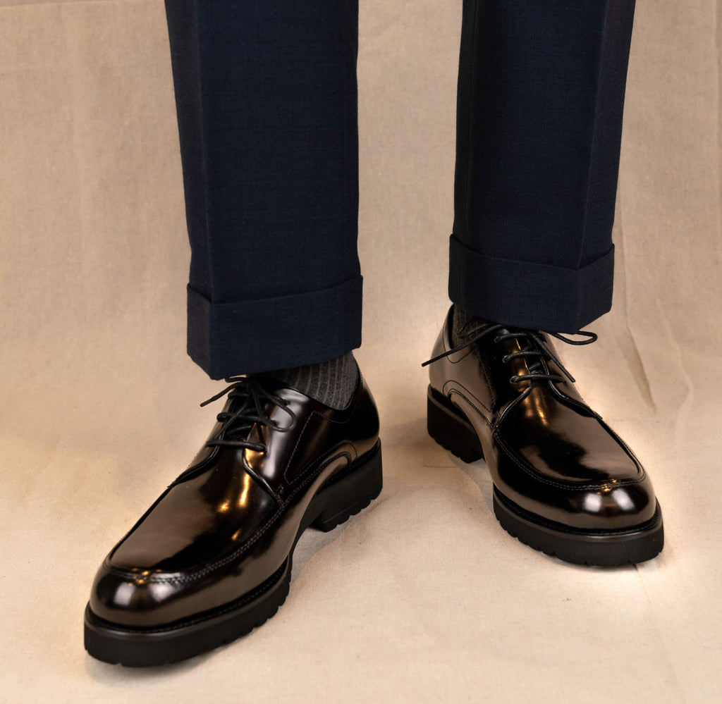 The Barmani Thick-Soled Business Black Derby (U-TIP) worn on a model with cuffed navy trousers
