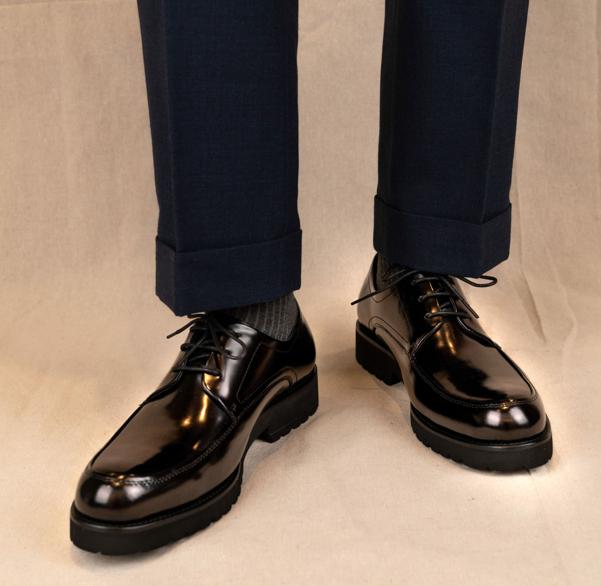 The Barmani Thick-Soled Business Black Derby (U-TIP) worn on a model with cuffed navy trousers