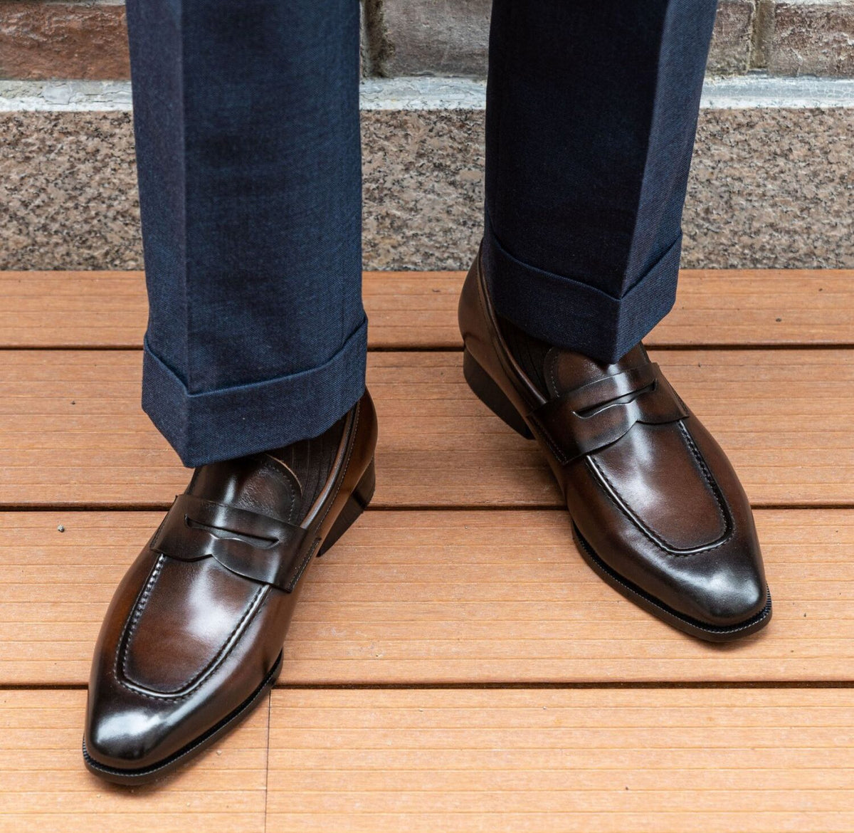 The Morton Brown Penny Loafer worn with cuffed navy trousers, outdoor deck