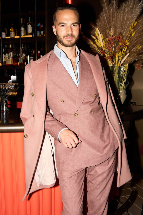 Dusty Rose Suit worn at a bar with the matching overcoat draped over one arm