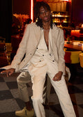 Cream Couture Suit with a houndstooth blazer worn open, model seated in a lounge