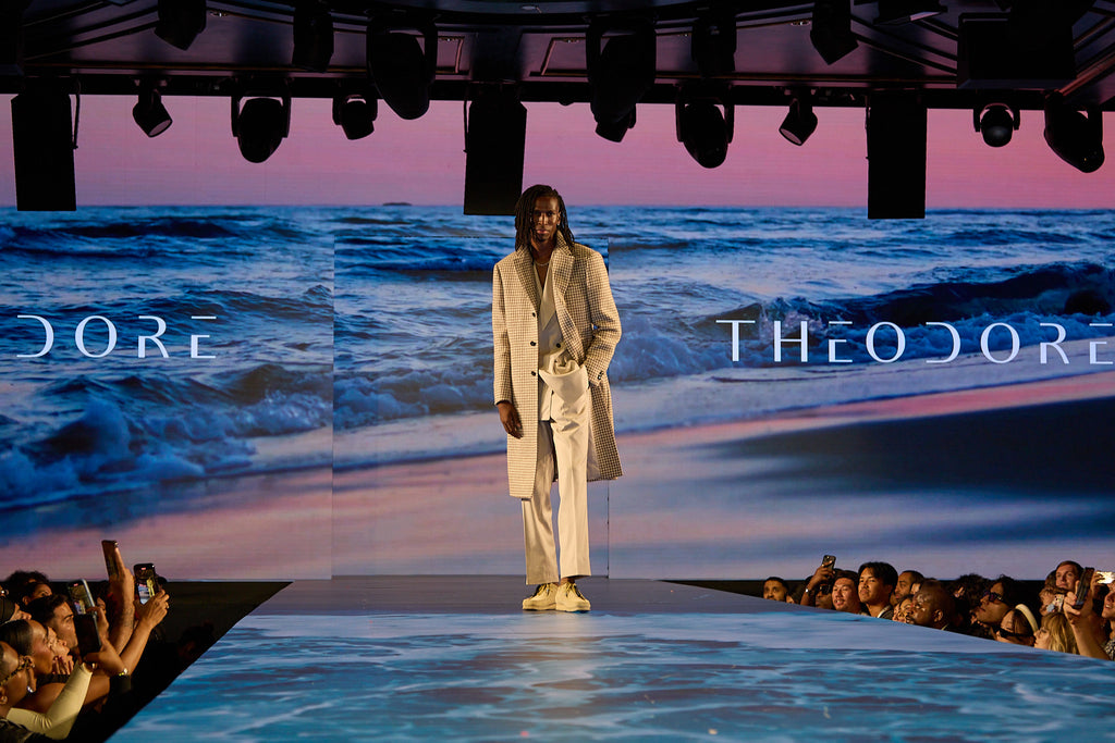 Cream Couture Suit worn full length, model walking the runway with an ocean backdrop