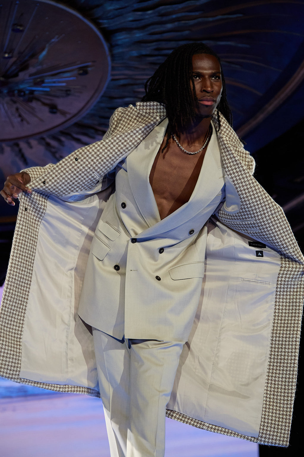 Cream Couture Suit, close-up of a model holding the houndstooth blazer open on the runway