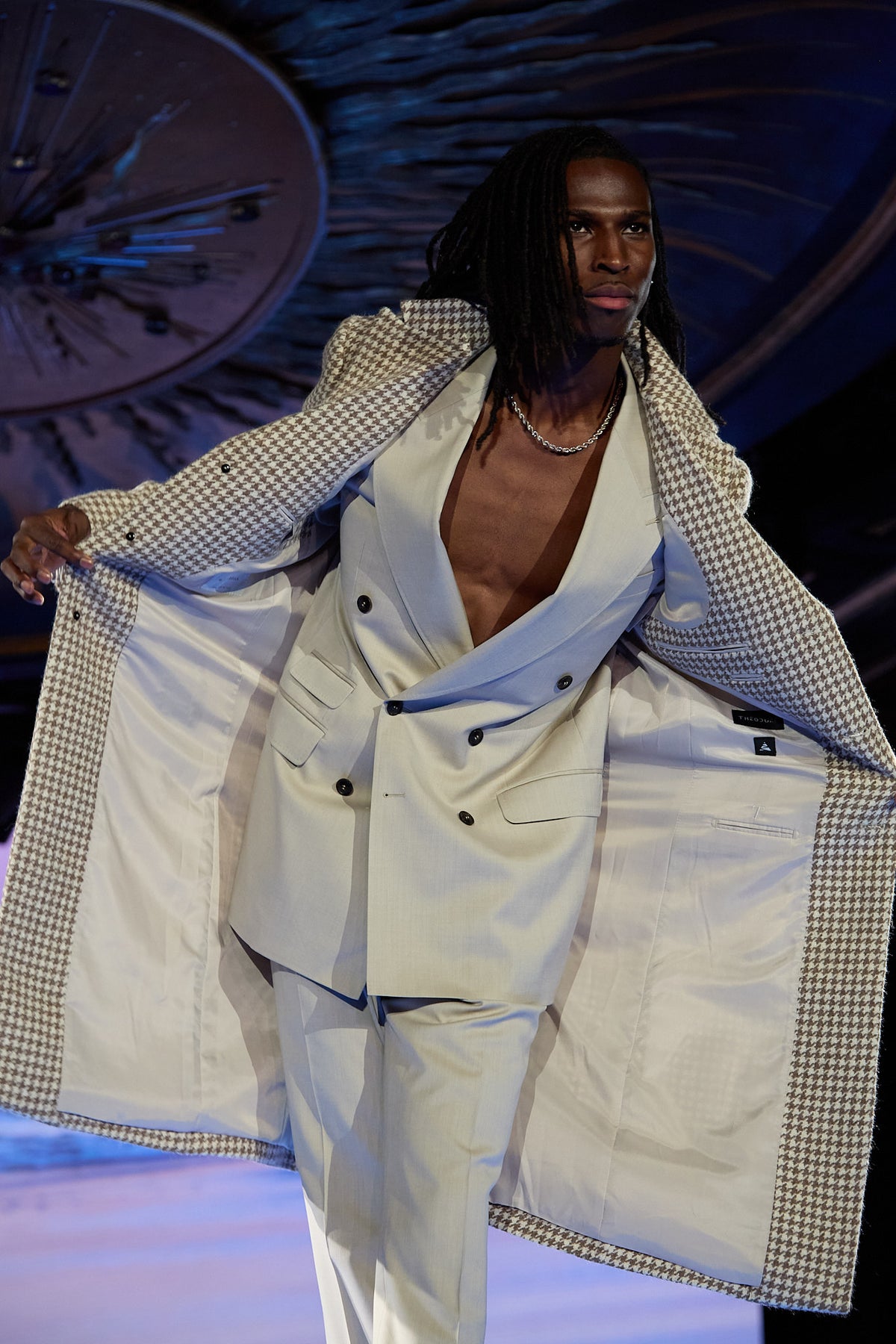 Cream Couture Suit, close-up of a model holding the houndstooth blazer open on the runway