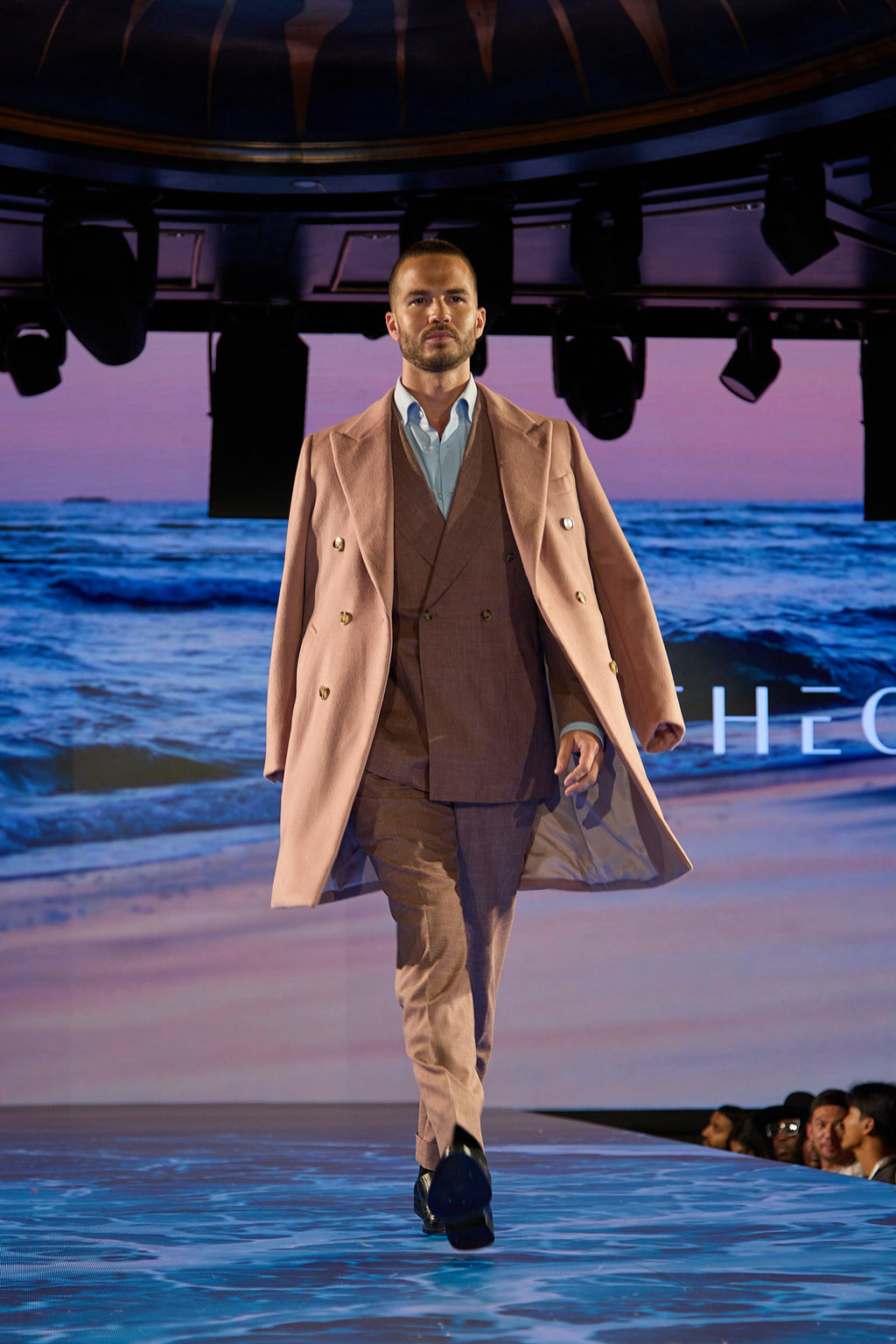 Dusty Rose Suit on the runway, closer mid-stride shot of a model walking toward camera