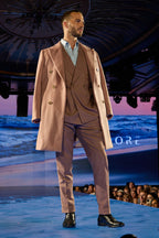 Rosewood Overcoat, a model walks the runway with the crowd visible beyond the stage