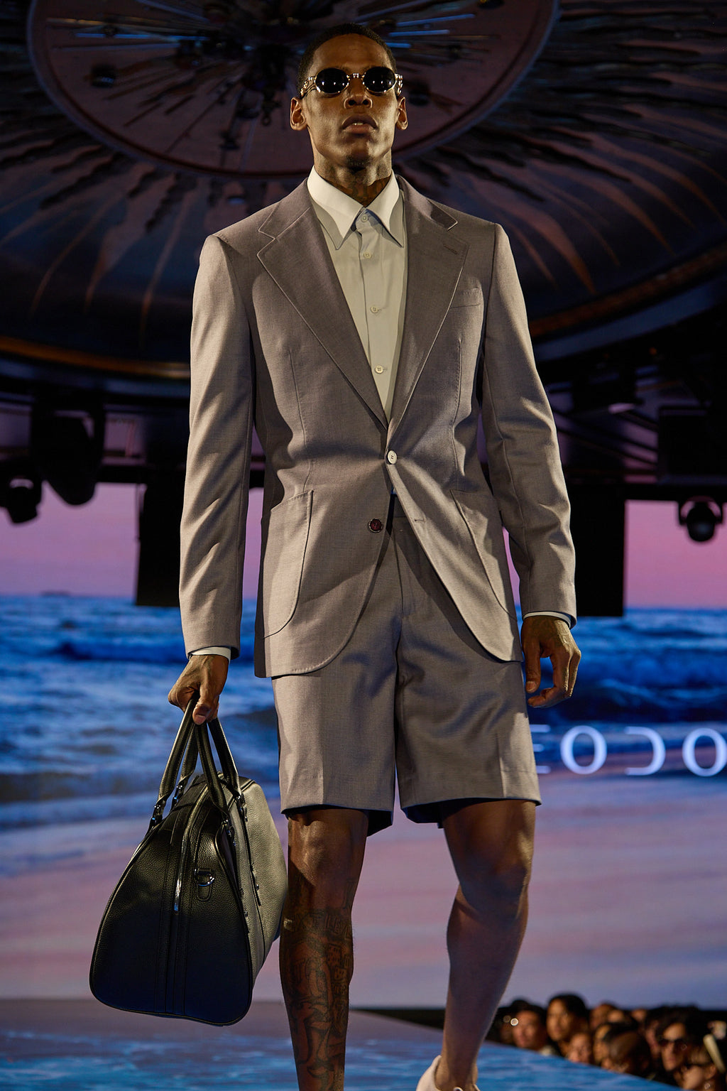 Lavender Haze Suit, closer runway shot of a model walking with a serious expression