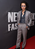 Zenith Grey Suit worn by a model standing at a fashion week media wall