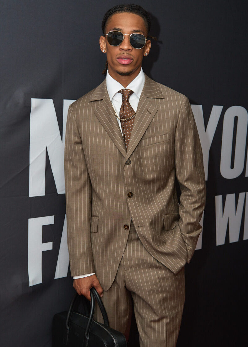 Beige Pinstripe Suit worn by a model with sunglasses at a fashion week step-and-repeat wall