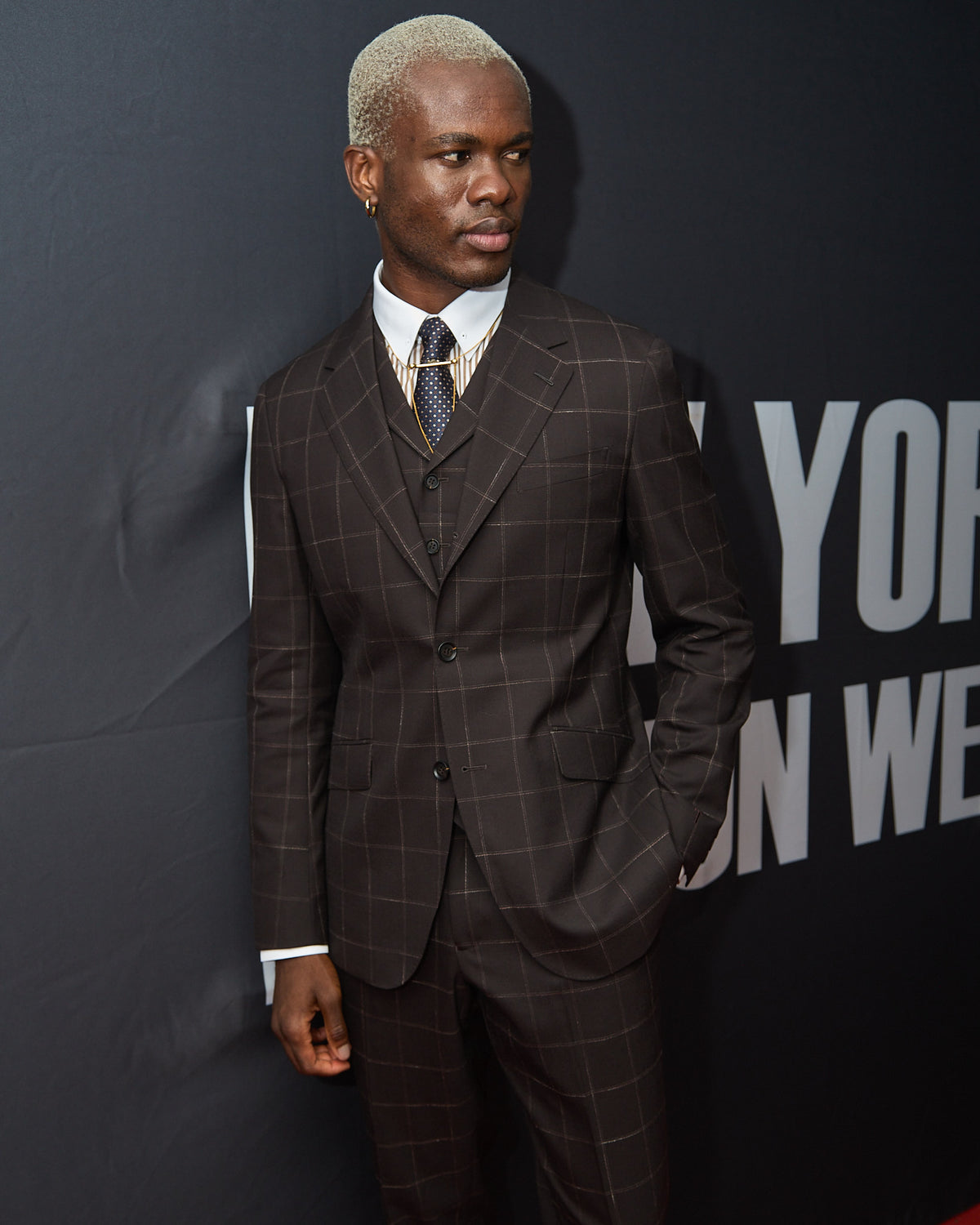 The Brown Capper Three Piece worn alone, model facing forward on a red carpet