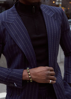 The No Filter Navy Pinstripe Suit jacket worn open over a black turtleneck, close-up on a model