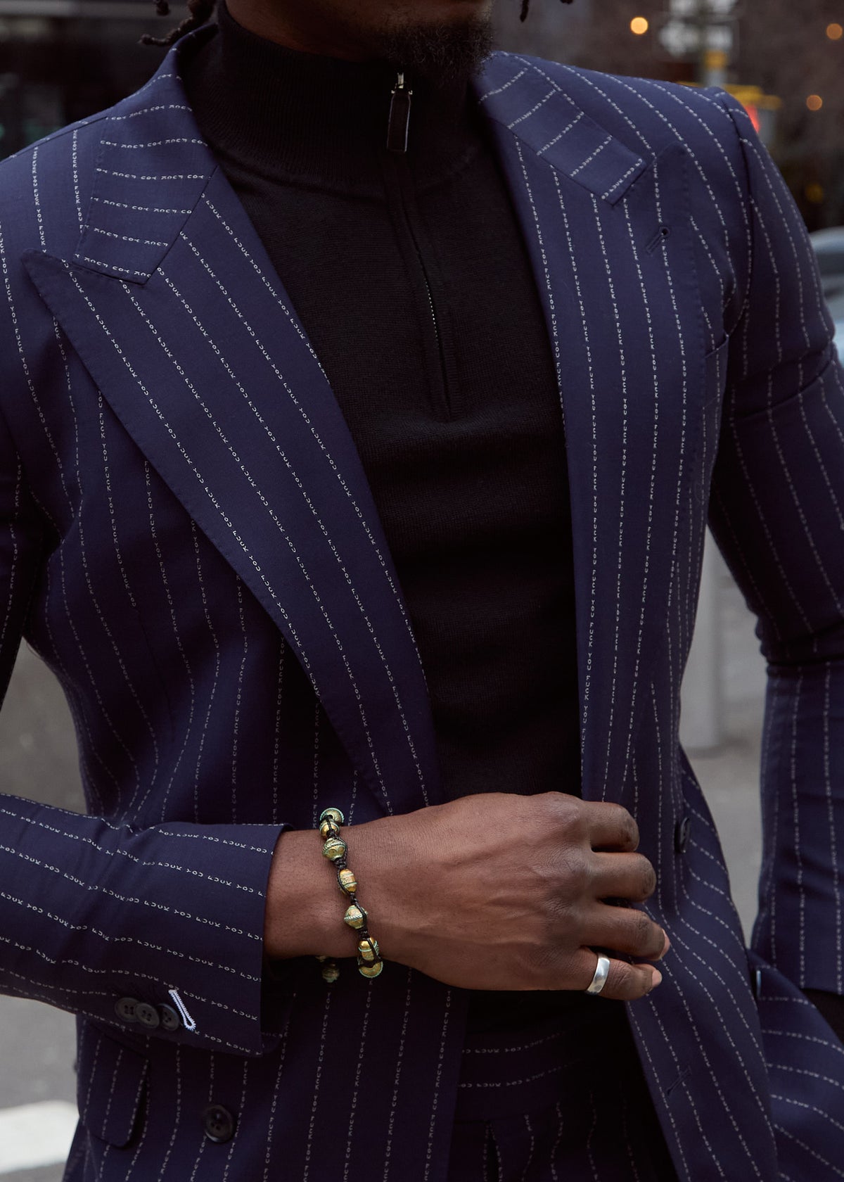 The No Filter Navy Pinstripe Suit jacket worn open over a black turtleneck, close-up on a model