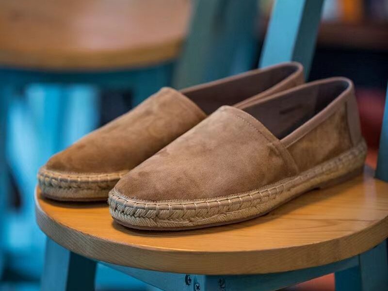 Aries Taupe Handcrafted Woven Fisherman Shoes, pair resting on a wooden stool