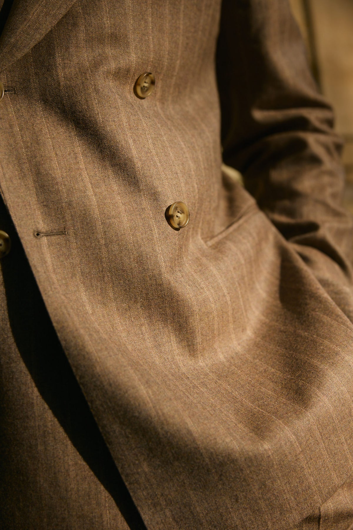 Close-up of the Langley suit's pinstripe fabric and button in sunlight