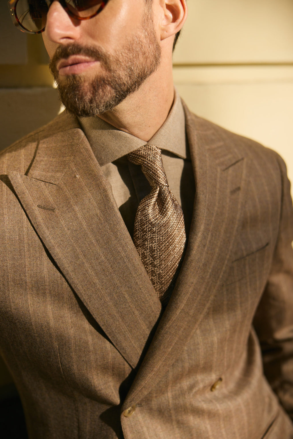 Langley brown pinstripe suit tie and lapel close-up on a model, sunlit