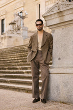 The Pembroke Brown Houndstooth Casual Set worn by a model on stone steps