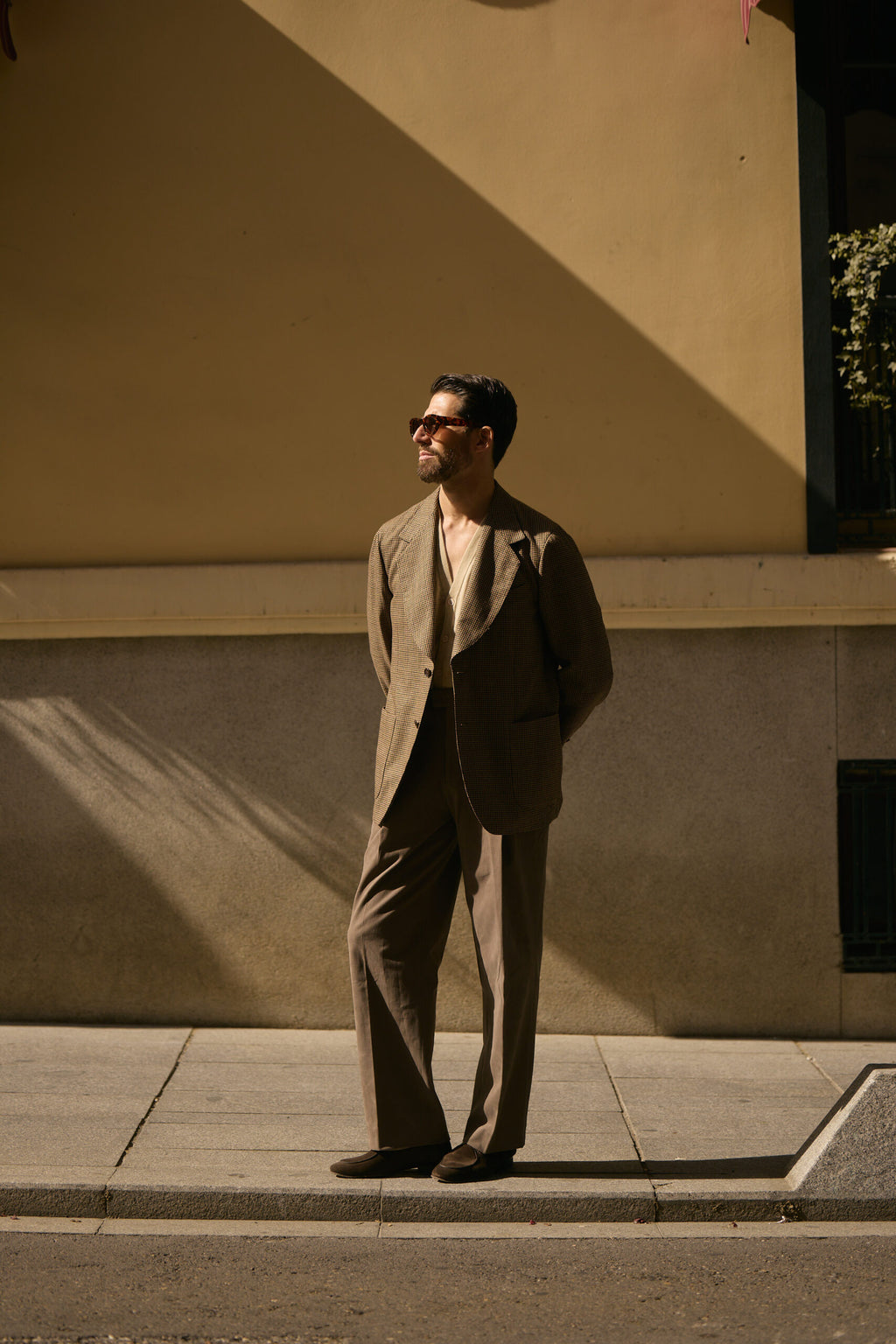 The Pembroke Brown Houndstooth Casual Set worn by a model against a yellow wall