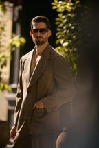 The Pembroke Brown Houndstooth Casual Set worn by a model beside green foliage