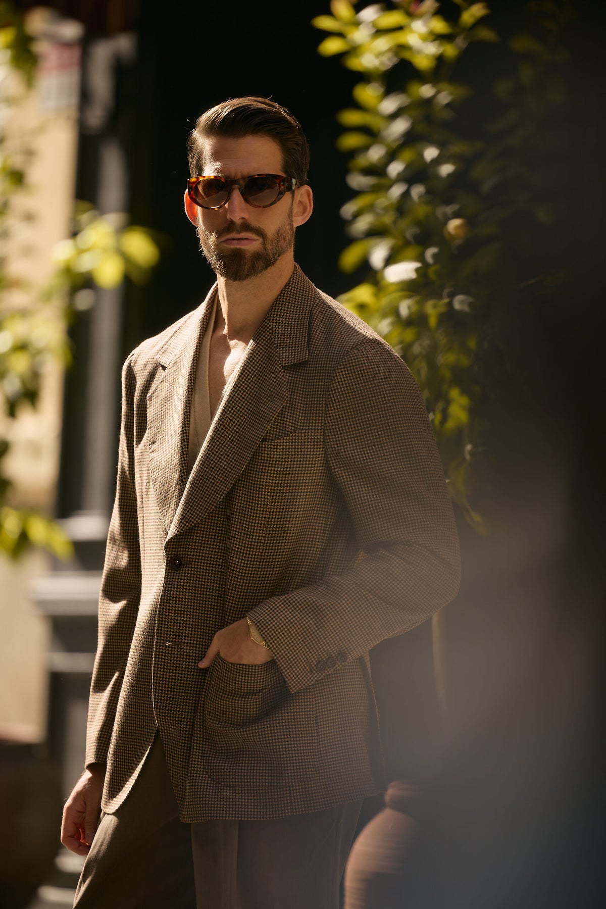 The Pembroke Brown Houndstooth Casual Set worn by a model beside green foliage