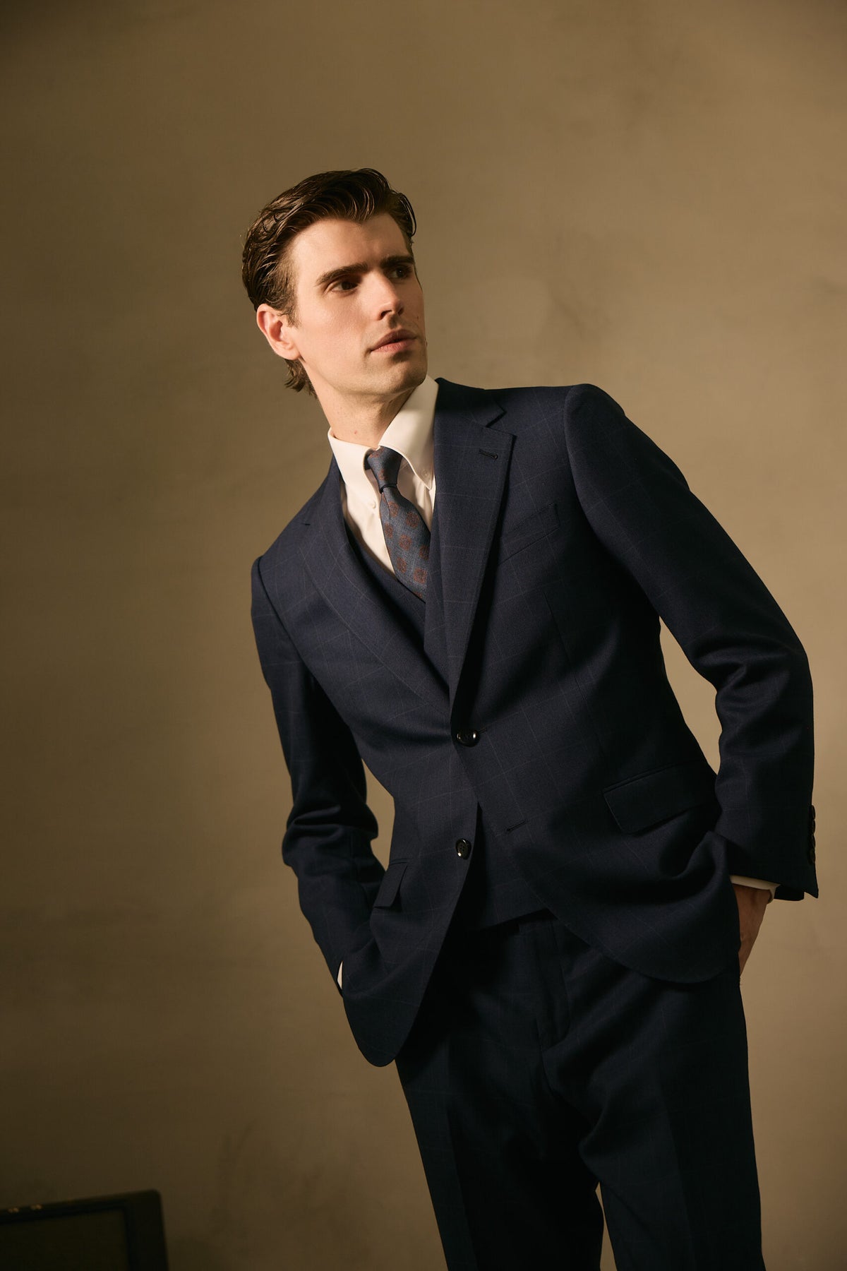 The Stratford Navy Check Suit worn by a model, hand in pocket, looking aside