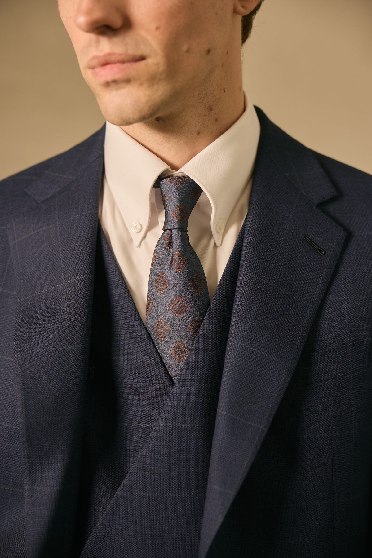 The Stratford Navy Check Suit, close-up of the tie, waistcoat and lapel pin