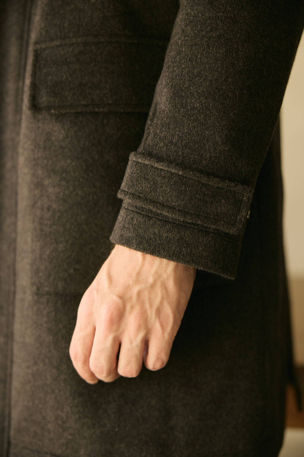 The Ashford Charcoal Overcoat, close-up of the buttoned cuff strap on the sleeve