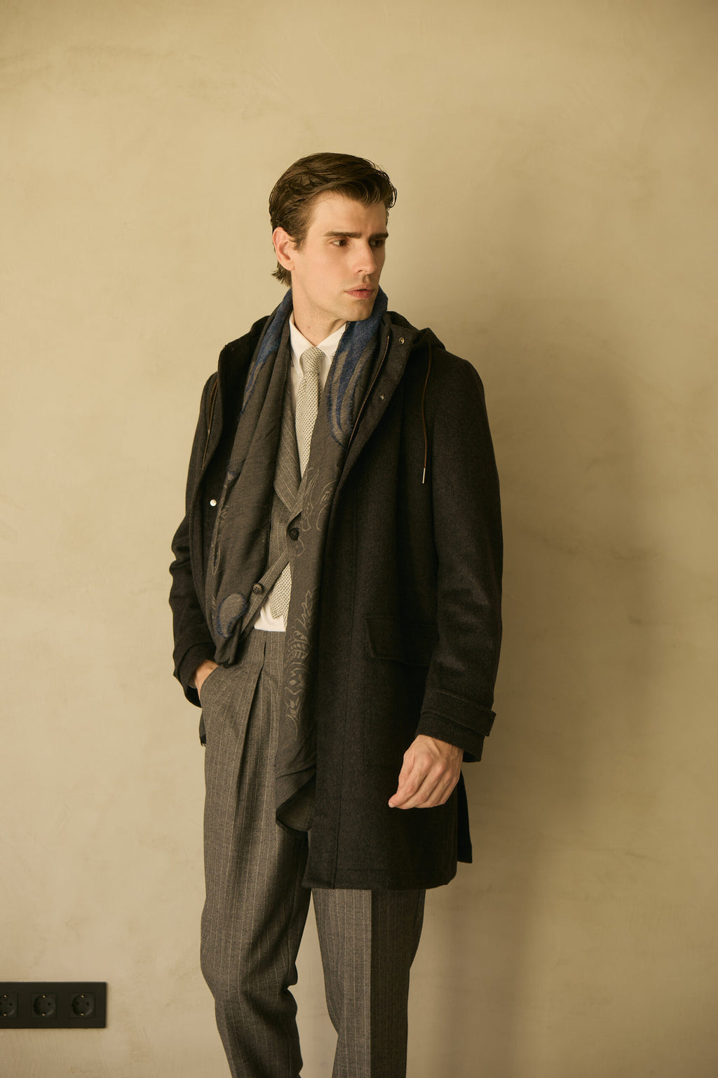 The Ashford Charcoal Overcoat, angled full-length shot with the model looking down