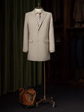 Kensington Park Beige Silk Blend Overcoat on a stand with a striped tie and duffel bag