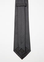 Amsterdam Silk Tie in black micro pattern, angled flat lay with tip turned back