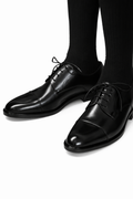 Soft leather split-toe black derby shown worn on a model's feet, both shoes visible