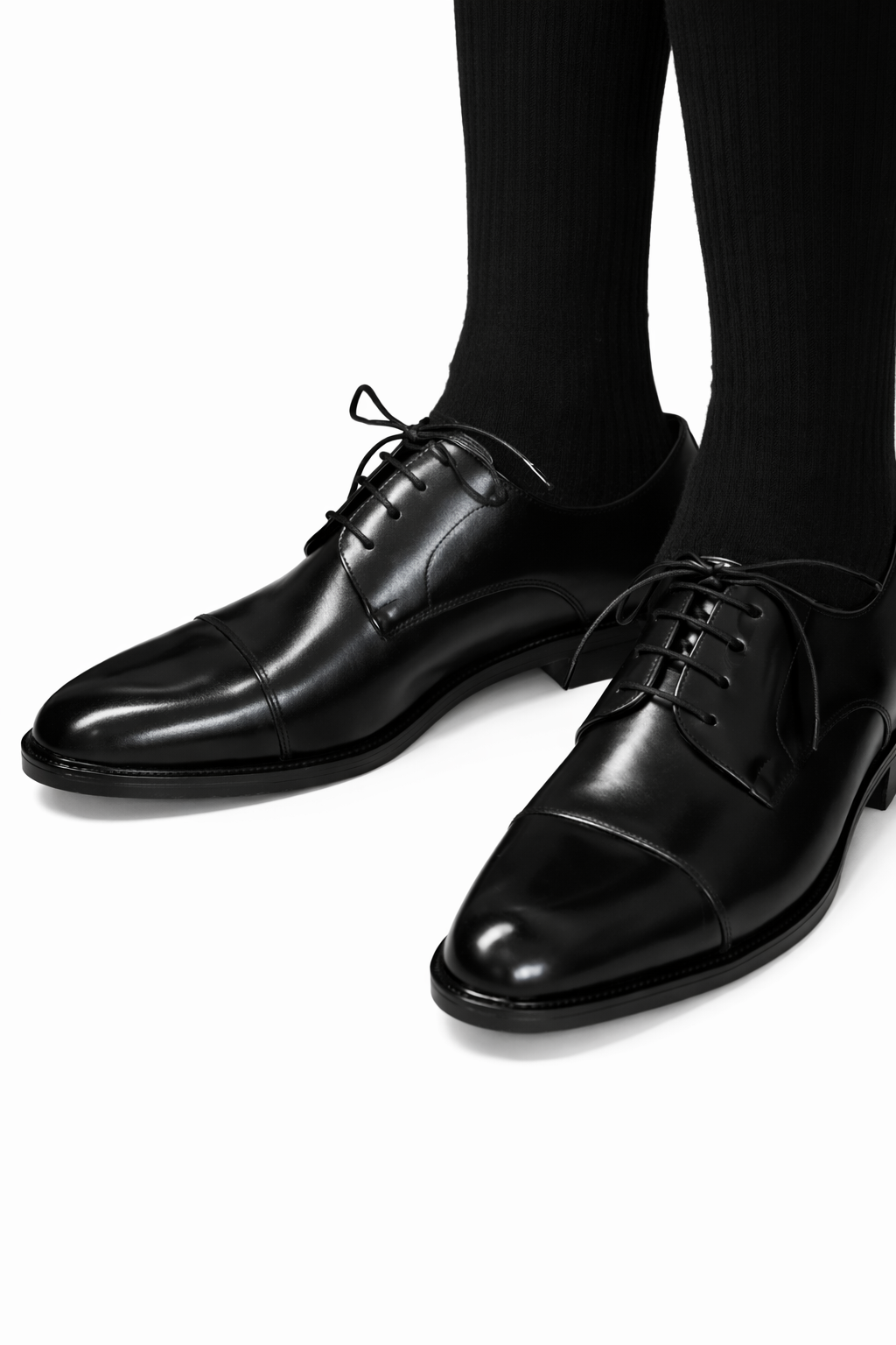 Soft leather split-toe black derby shown worn on a model's feet, both shoes visible