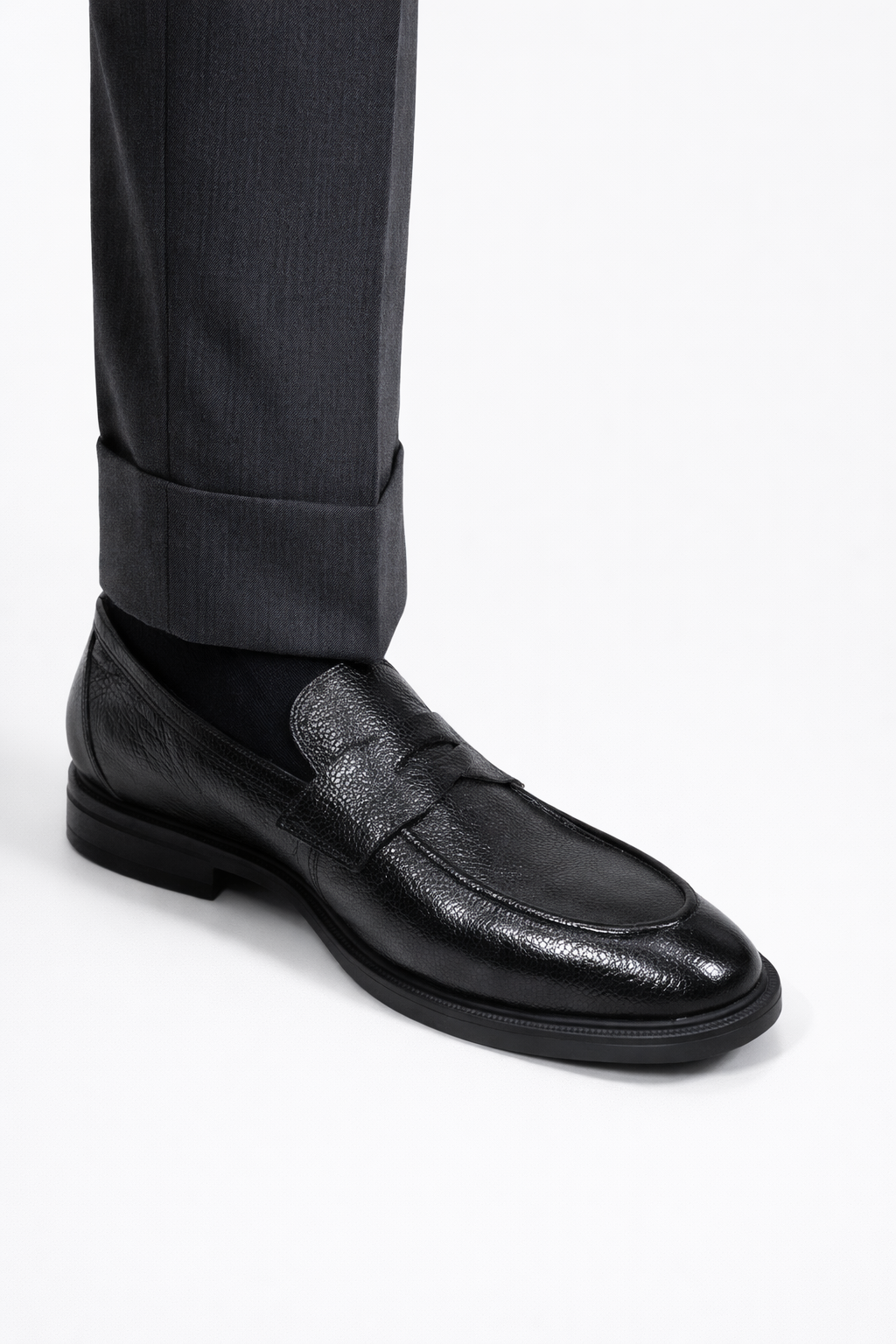 Gaston Black Pebbled Deerskin Penny Loafers worn on a model, close-up with trouser cuff