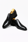 The Dino Wholecut Brogue Black Oxfords pair in glossy black leather, product shot