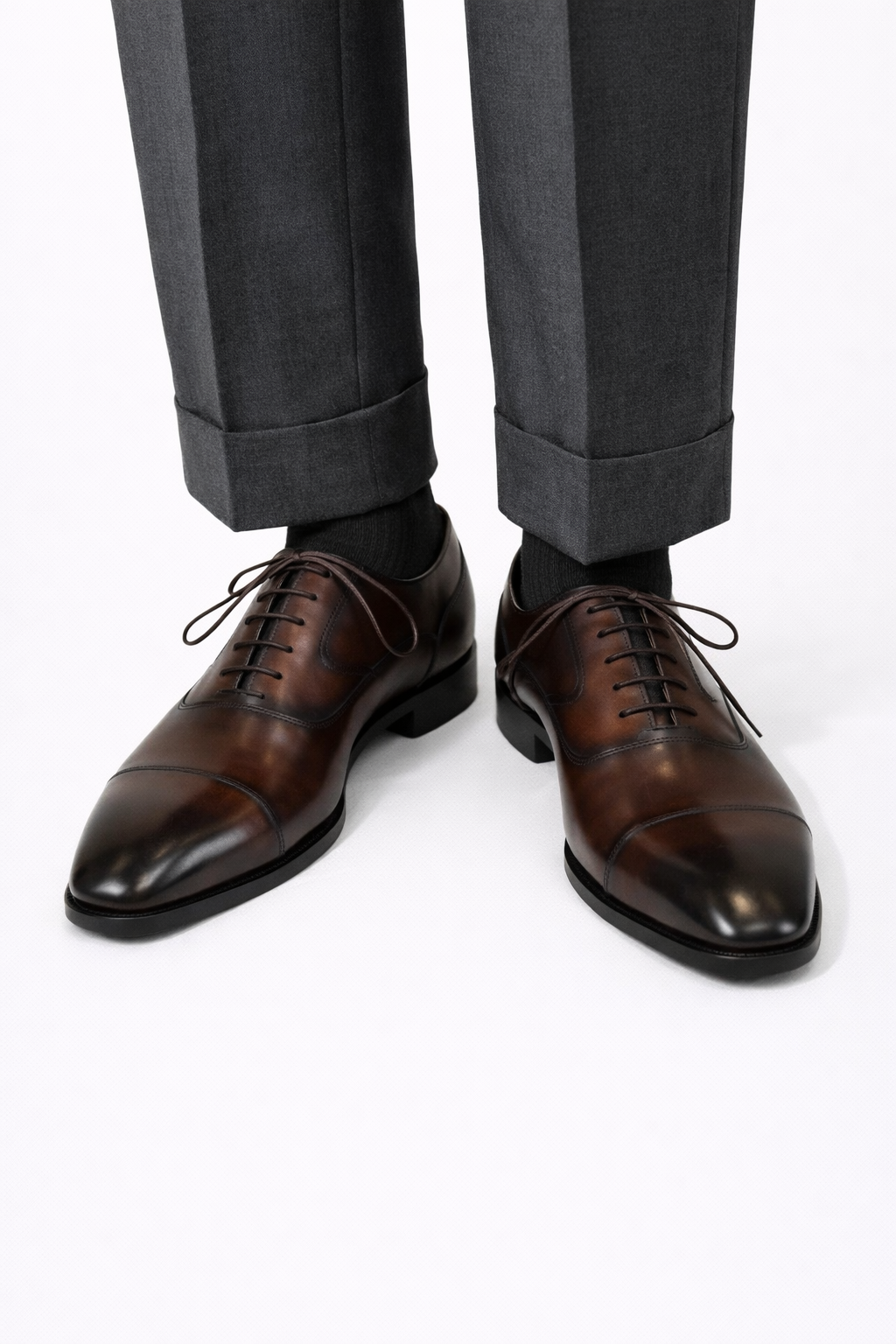 The Konbanwa Square-Toe Triple-Stitched Brown Oxford worn on a model with cuffed grey trousers