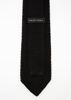 Hong Kong Tie in knit black silk, close-up of the Theodore label on the keeper loop