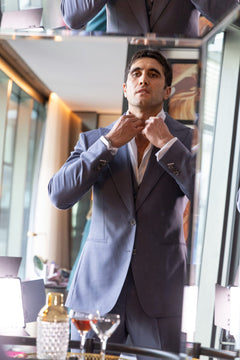 The Vivid Voltage Steal Grey Suit worn by a model adjusting the collar