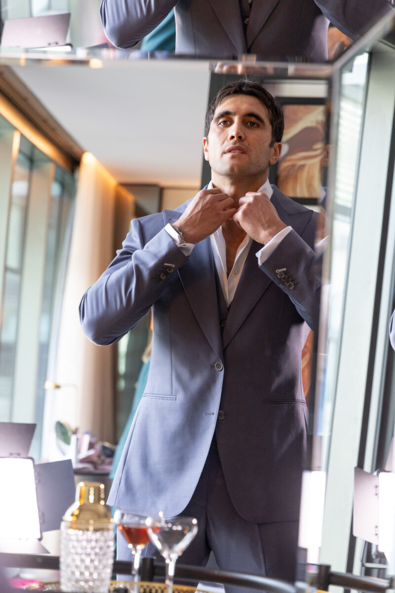 The Vivid Voltage Steal Grey Suit worn by a model adjusting the collar
