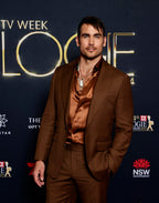Modern Mellow brown suit on a model at the same red carpet event, different pose