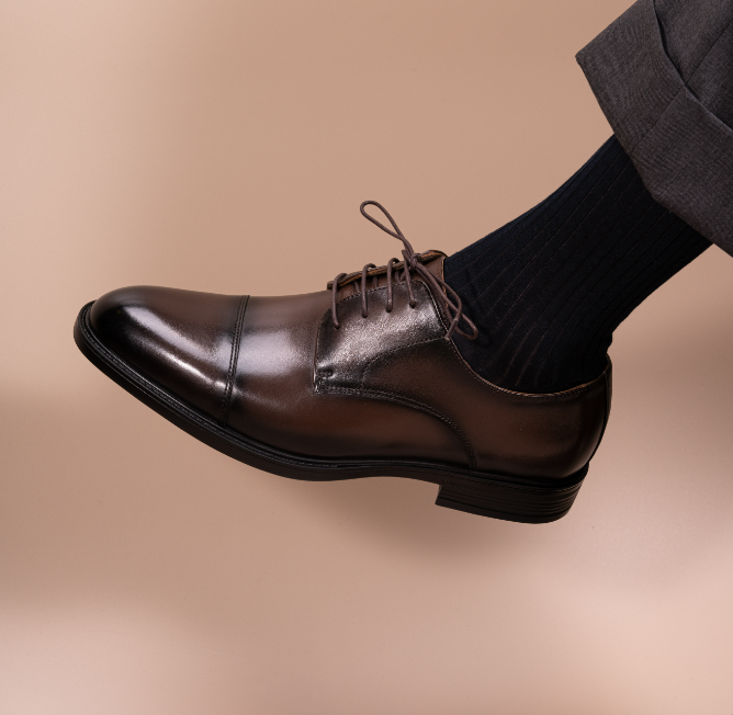 Soft leather split-toe brown derby shown worn on a model's foot, angled view