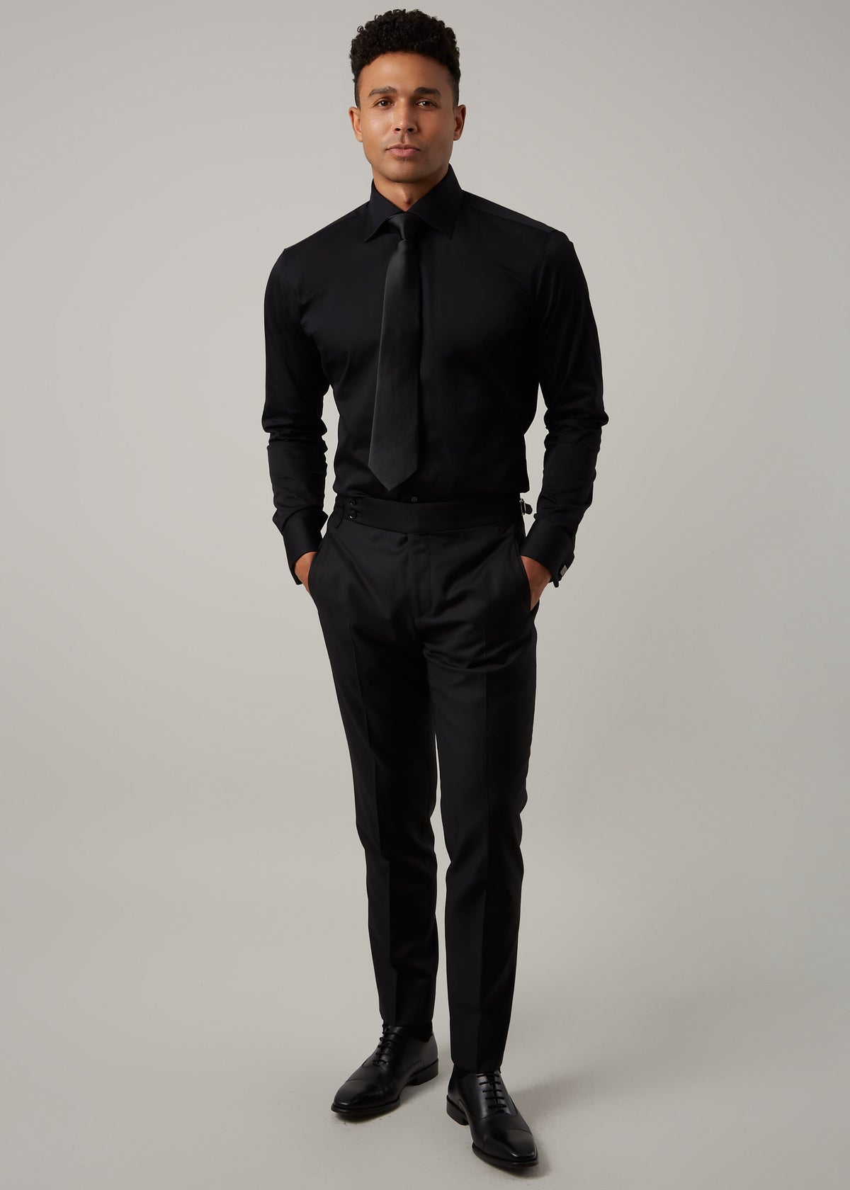 Our Perfect Black Shirt worn with a black tie and trousers, full-length front view