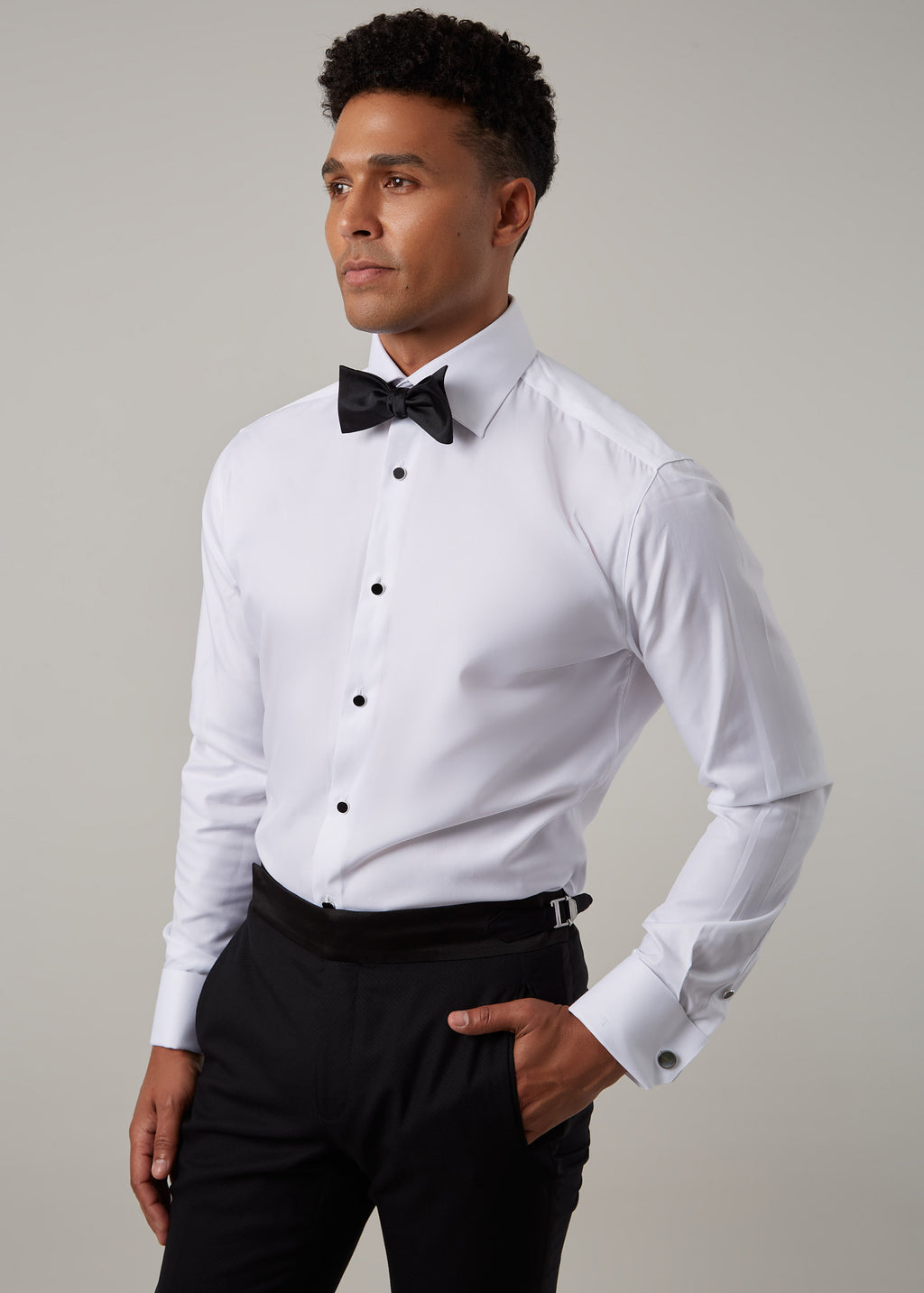 Glamorous Tuxedo Shirt worn with a bow tie, model turned to the side, hand in pocket