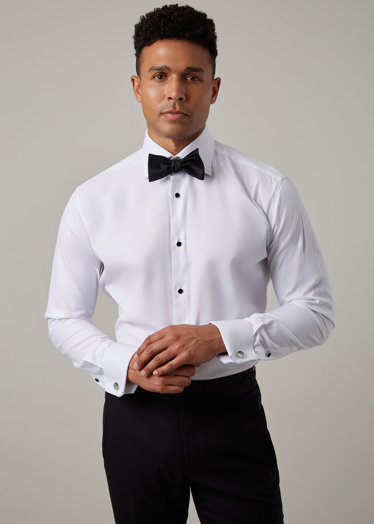 Glamorous Tuxedo Shirt with black bow tie and studs, front view, hands clasped