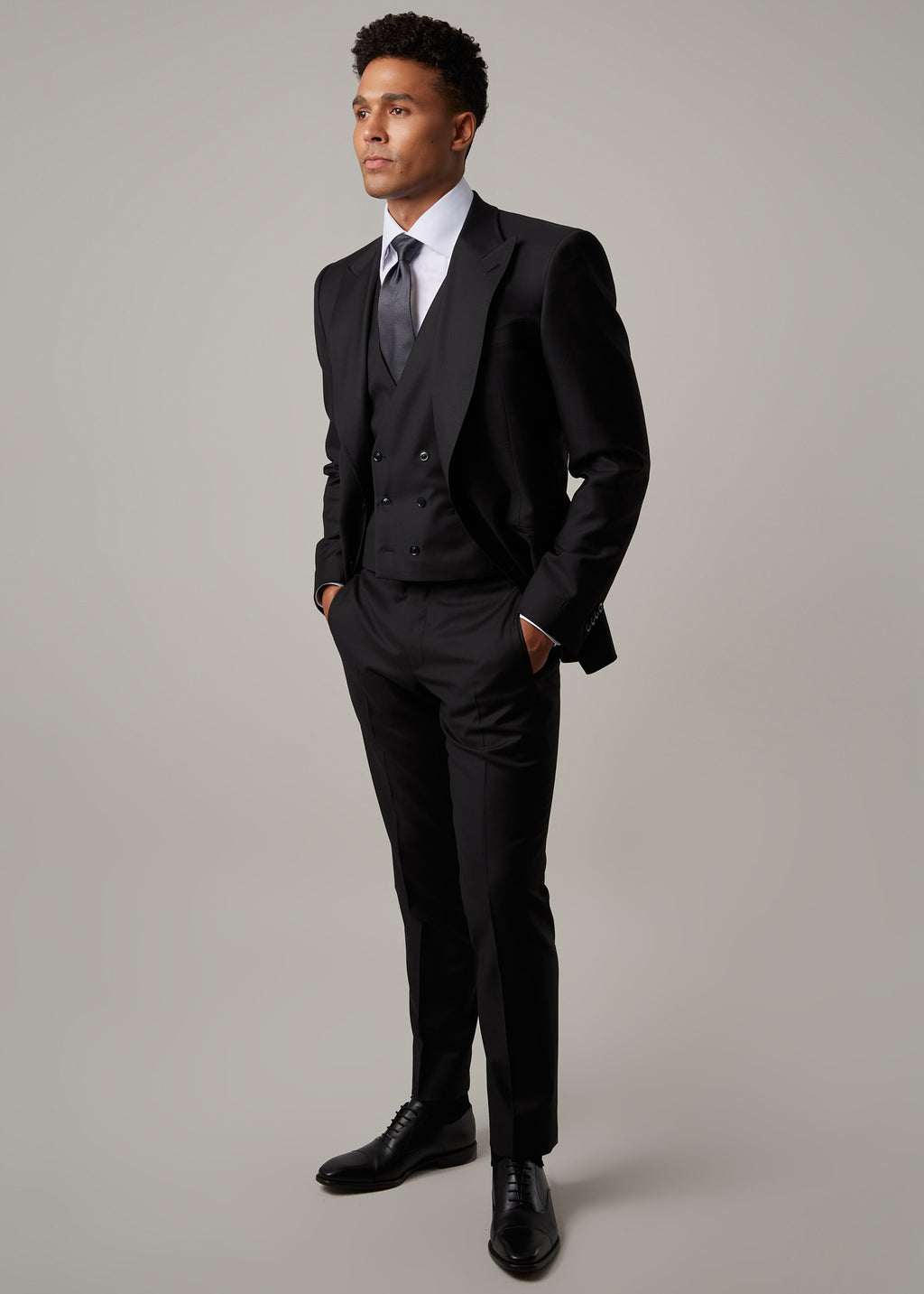 Midnight Milano The Ultimate Black Suit worn with a waistcoat, gaze turned to the side