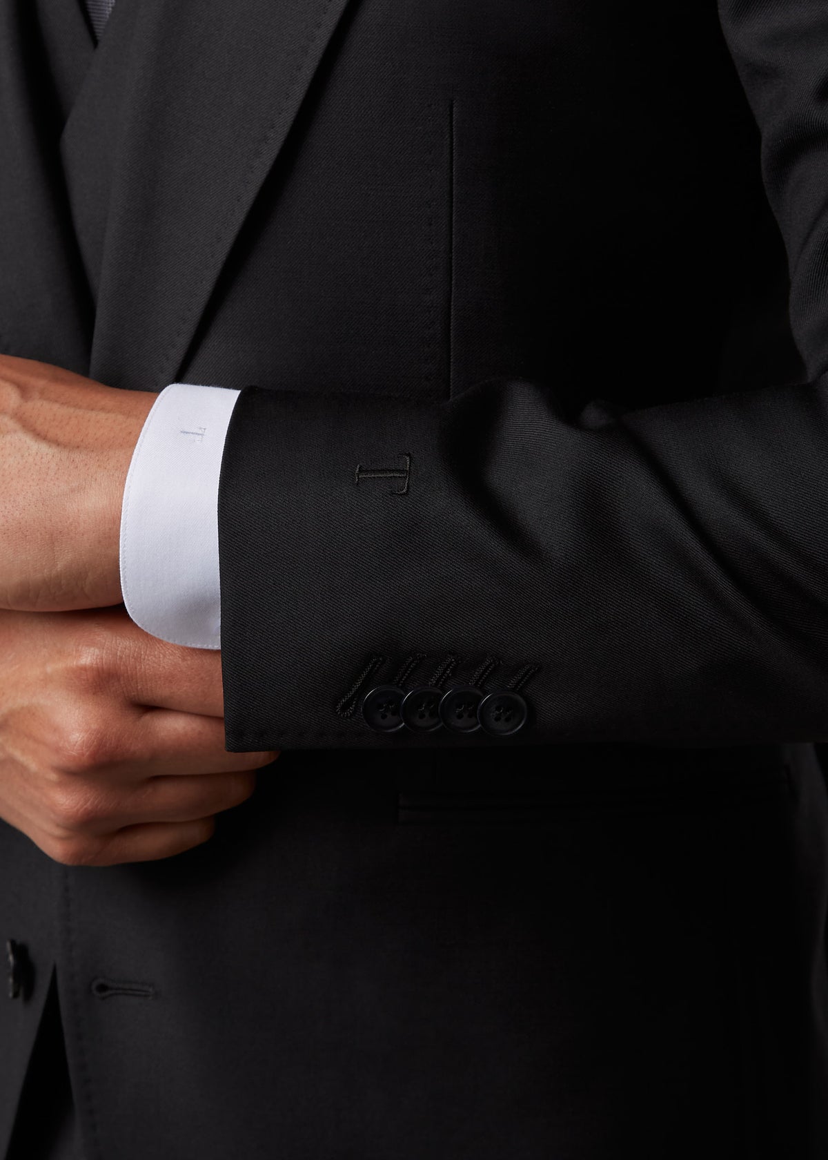 Midnight Milano The Ultimate Black Suit, close-up of the sleeve cuff and monogrammed shirt placket