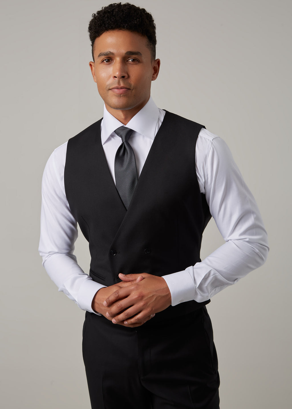 Midnight Milano The Ultimate Black Suit waistcoat worn alone, hands clasped at the waist