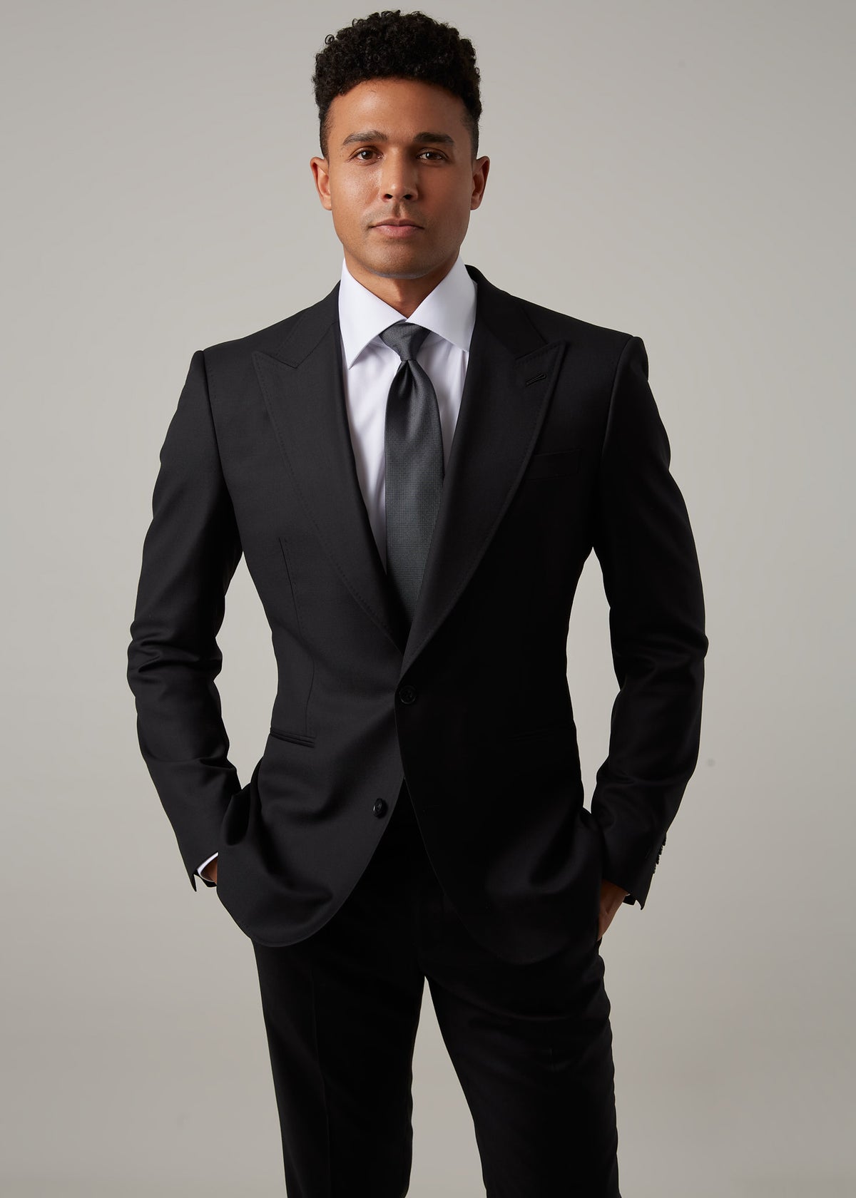 Midnight Milano The Ultimate Black Suit worn full-length, gazing directly at the camera