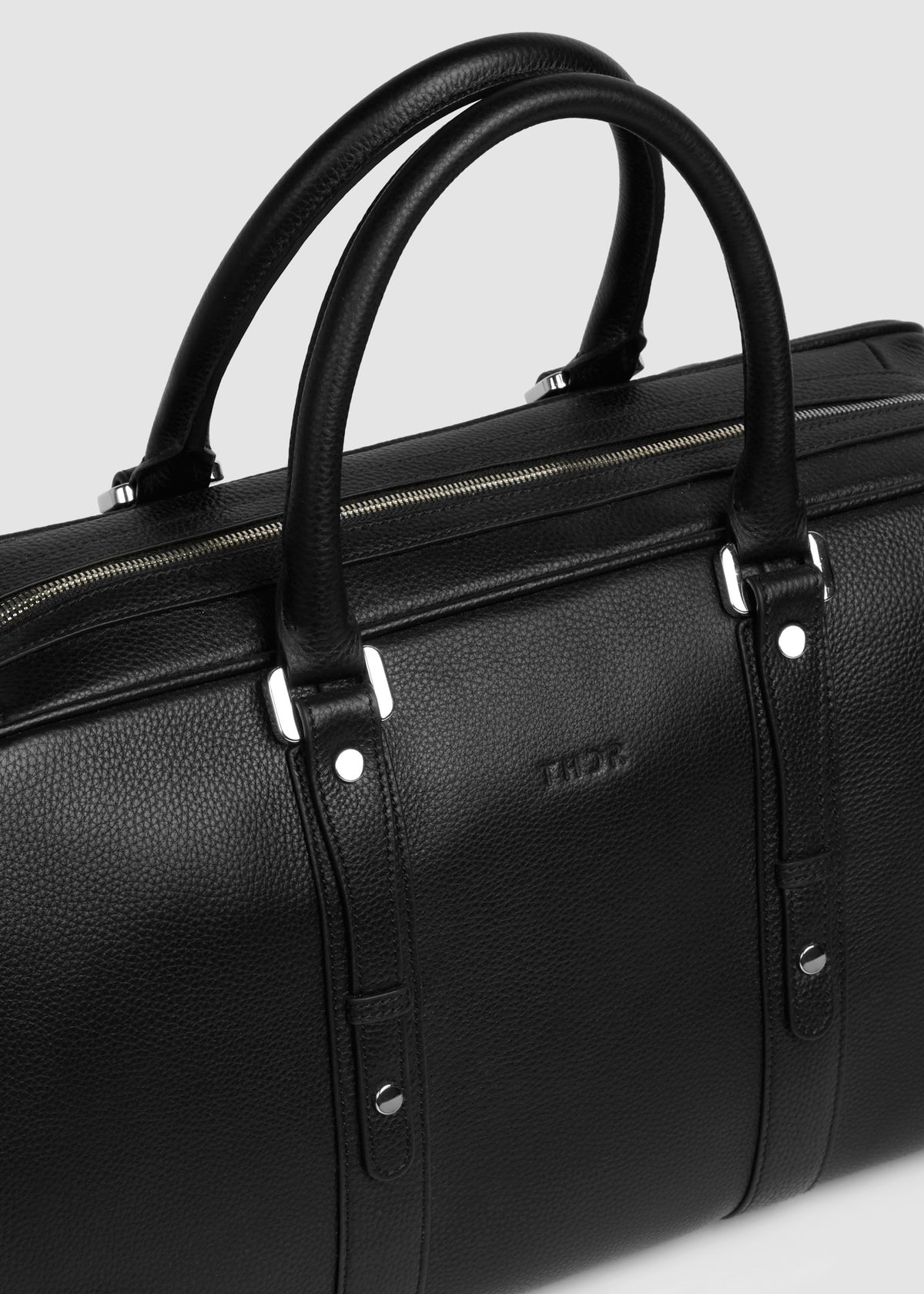 Close-up of the Christian travel bag's handles and embossed THDR logo