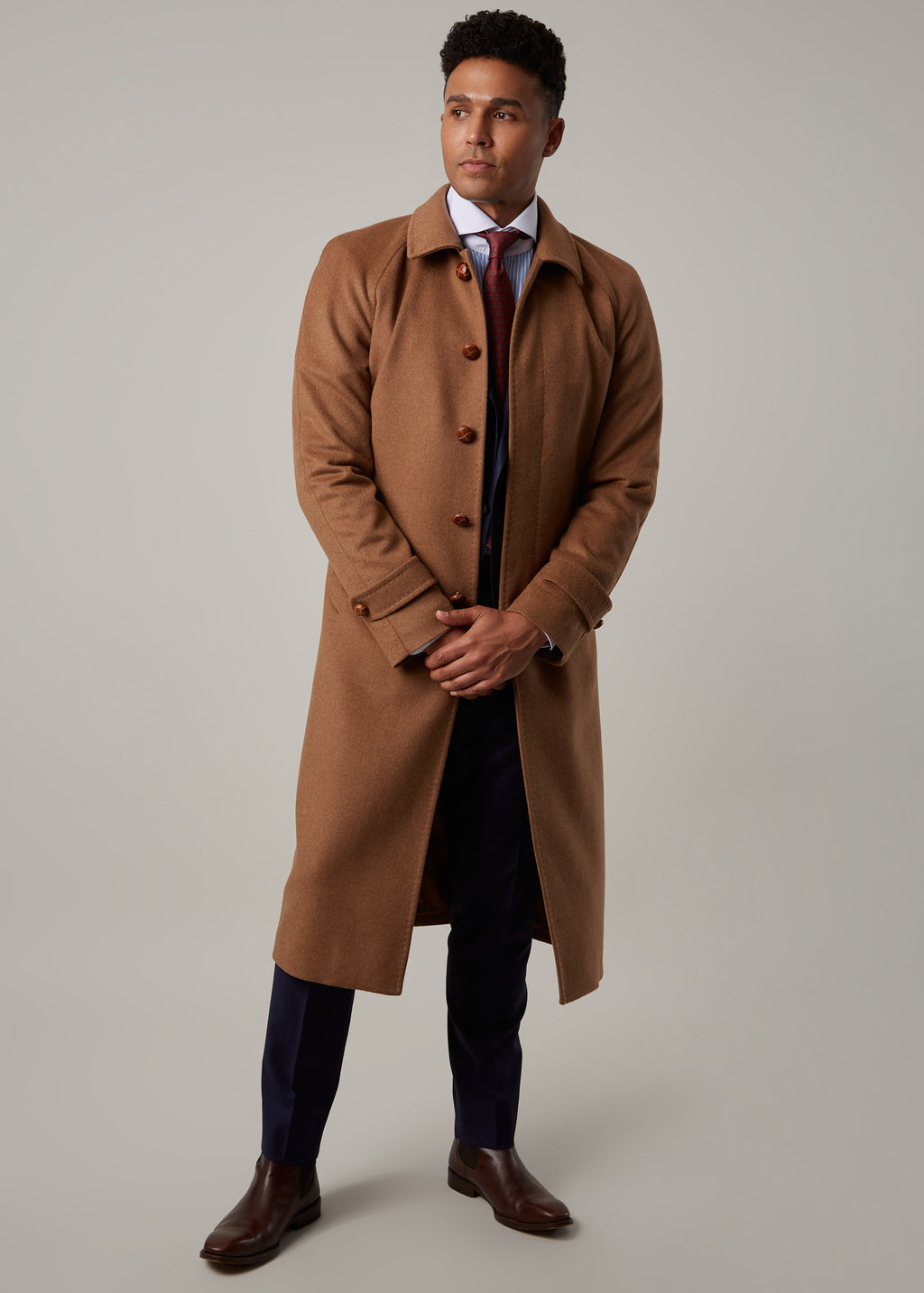 Toasty Truffle Cashmere Blend Overcoat fully buttoned, standing with hands clasped